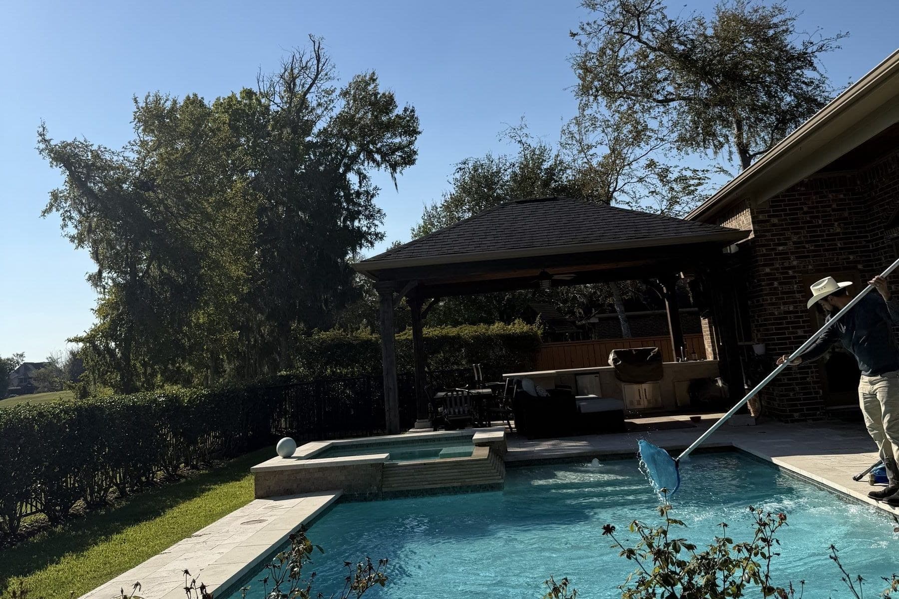 Pool technician brushing pool walls