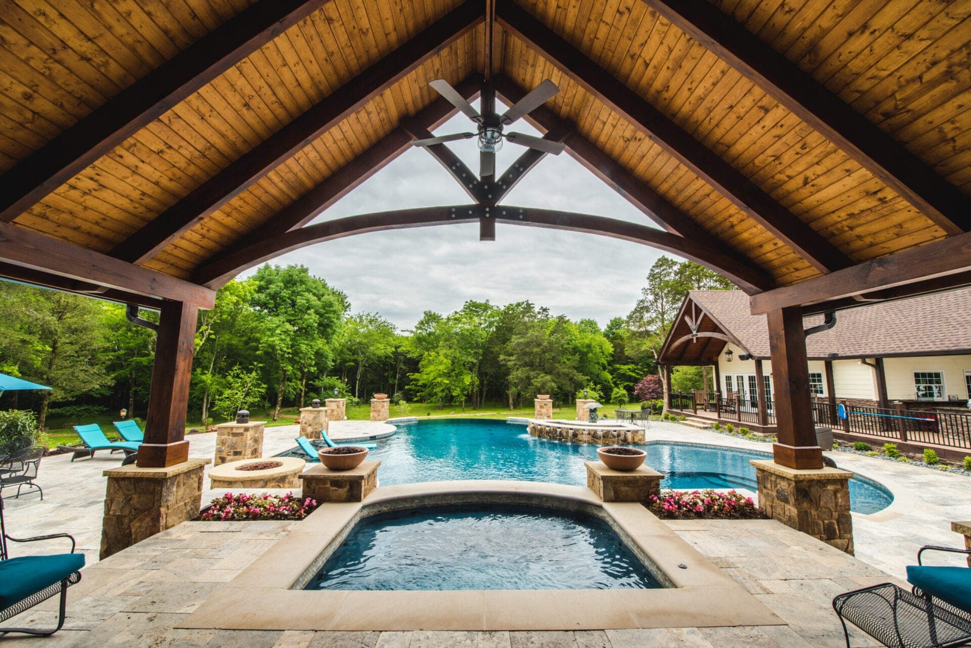 Luxury freeform pool with pavilion, spa, and fire bowls
